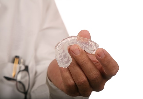 Dentist holding a mouthguard in his hand at Cascade Dental in Medford, OR