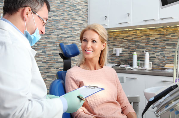 Woman talking to dentist during dental exam at Cascade Dental in Medford, OR