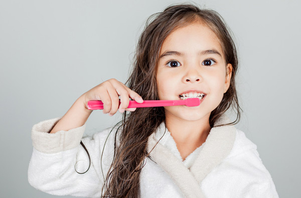 Young girl brushing her teeth at Cascade Dental in Medford, OR Young girl brushing her teeth at Cascade Dental in Medford, OR